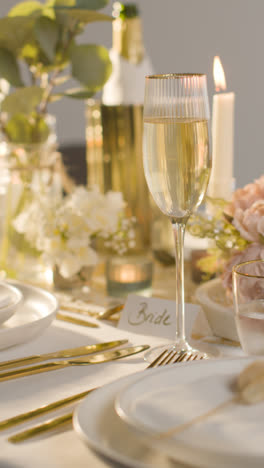 Vertical-Video-Of-Table-Set-For-Meal-At-Wedding-Reception-With-Champagne-And-Place-Card-For-Bride-1